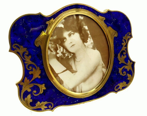 Salimbeni Guilloche Frame Hand-Engraved Shaped photo frame with oval interior in 925/1000 sterling silver gold plated . Oval Shape with blue back ground and gold plated hand-carved decoration. Right side front view