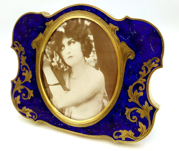 Salimbeni Guilloche Frame Hand-Engraved Shaped photo frame with oval interior in 925/1000 sterling silver gold plated . Oval Shape with blue back ground and goldplated hand-carved decoration. Right side front view